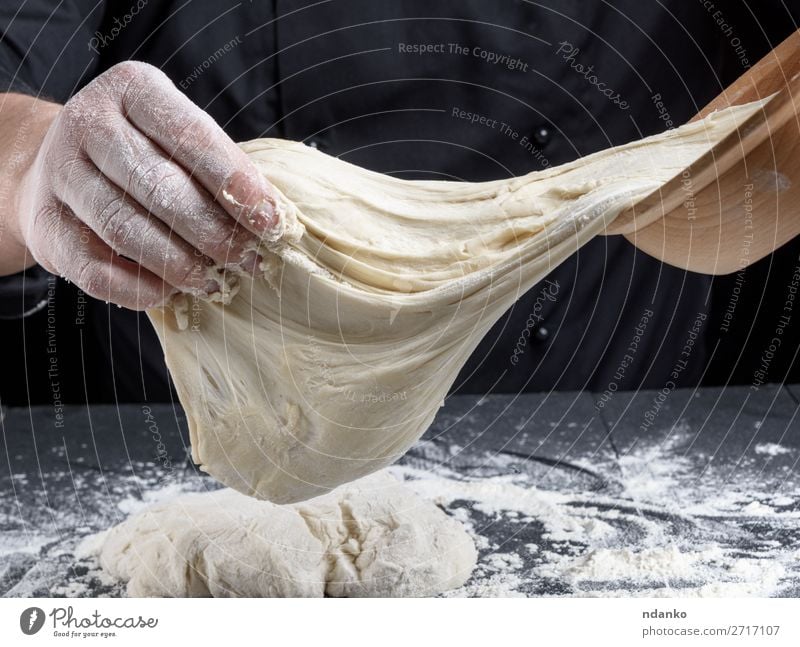 in schwarzen Uniformkneten kochen Weißweizenmehlteig Teigwaren Backwaren Brot Ernährung Haut Tisch Küche Beruf Koch Mensch Mann Erwachsene Hand Holz machen weiß