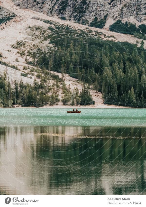 Menschen im Boot schwimmen im See Wasserfahrzeug Berge u. Gebirge Abenteuer Ausflug Außenaufnahme Erholung Panorama (Bildformat) Landschaft Gelassenheit