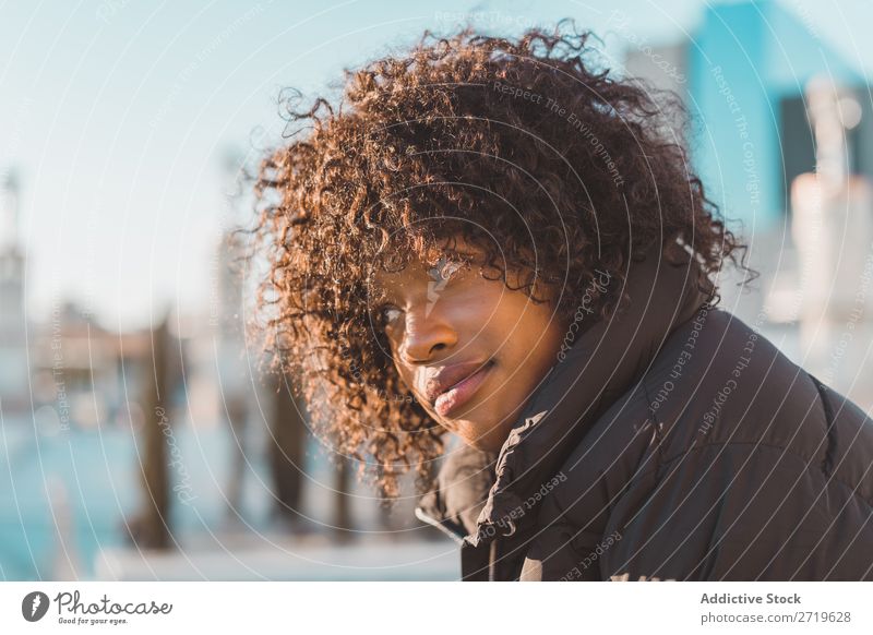 Stilvolle Frau auf dem Zaun sitzend urwüchsig hübsch schön Jugendliche Großstadt Park lässig Coolness Porträt Mensch attraktiv lockig schwarz Gesicht