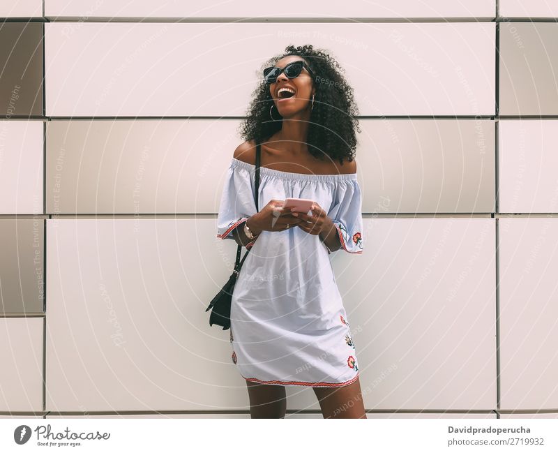 Fröhliche schwarze Frau mit Handy Wand Erwachsene lässig PDA Afrikanisch urwüchsig Textfreiraum heiter Jugendliche Lifestyle Pastell Hintergrundbild Mitteilung
