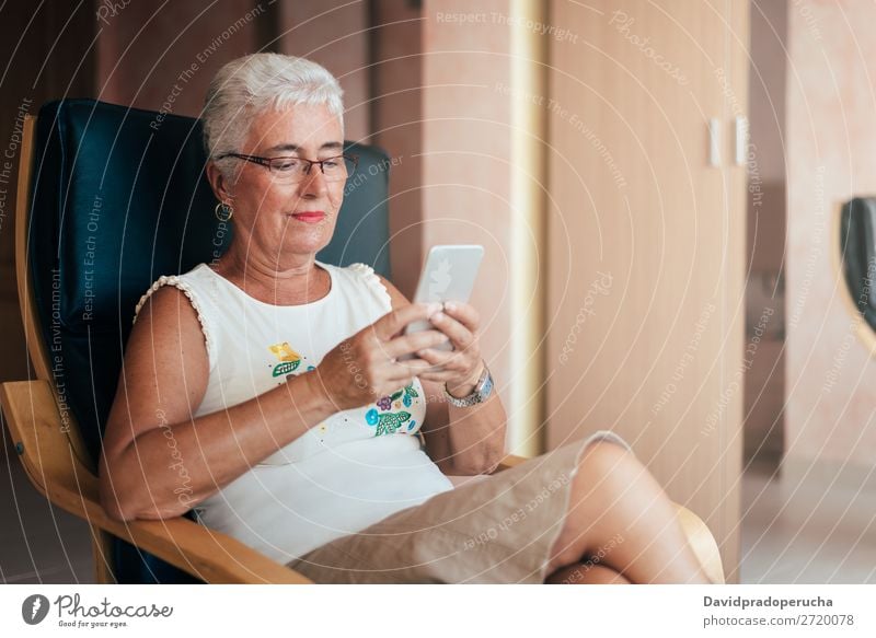 Ältere Frau auf dem Handy zu Hause graue Haare PDA alt heimwärts Mitteilung in den Ruhestand getreten Mensch Technik & Technologie Freizeit & Hobby sitzen