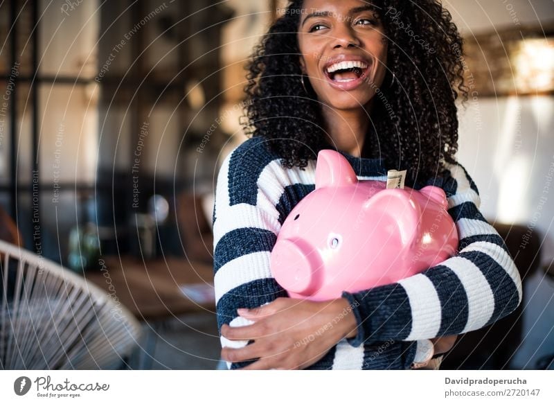 Schwarze Frau umarmt ihr Sparschwein. Spardose Einsparungen Erfolg Business Bargeld schwarz Geld Geldmünzen US-Dollar schön Glück heiter Investition Vermögen