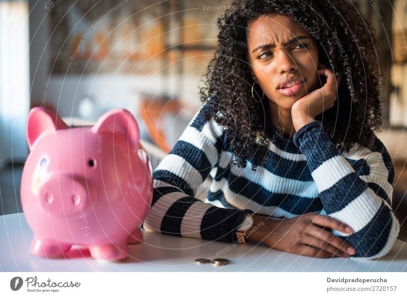 Nachdenklich verwirrte schwarze Frau mit Spardose Fürsorge Schulden Krise Ausdruck Irritation Fehler Traurigkeit Haushaltsplan beunruhigt enttäuscht