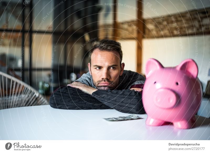 Trauriger frustrierter Mann mit Sparschwein Spardose Schulden Krise Traurigkeit Haushaltsplan Wut beunruhigt Kapitalwirtschaft verärgert Stress Fürsorge