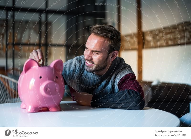 Glücklicher junger Mann mit Sparschweinbank Spardose Einsparungen Erfolg Business Bargeld Kaukasier Geld Geldmünzen Euro schön heiter Investition Vermögen
