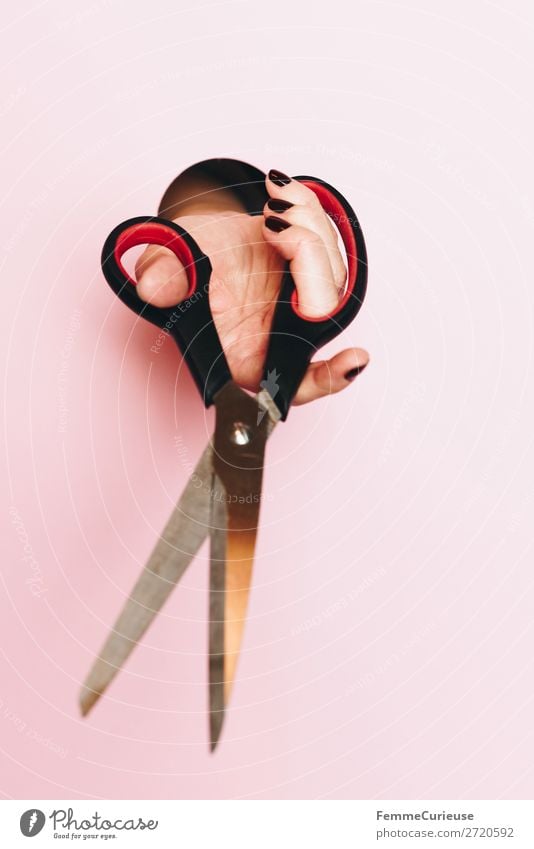 A woman's hand holding scissors Schreibwaren Papier Zettel Kreativität Design Basteln rosa ausschneiden Kreis Schere Hand Nagellack Werkzeug abschneiden