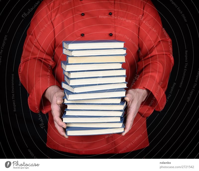 Mann in roter Uniform hält einen Stapel Bücher. elegant Küche Schule lernen Beruf Koch Erwachsene Hand Buch Bibliothek Bekleidung Jacke Papier stehen schwarz