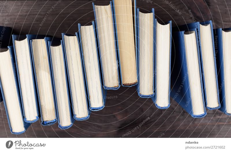 Stapel von Büchern in einem blauen Umschlag lesen Tisch Wissenschaften Schule Studium Menschengruppe Buch Bibliothek Papier Sammlung Holz braun gelb Weisheit