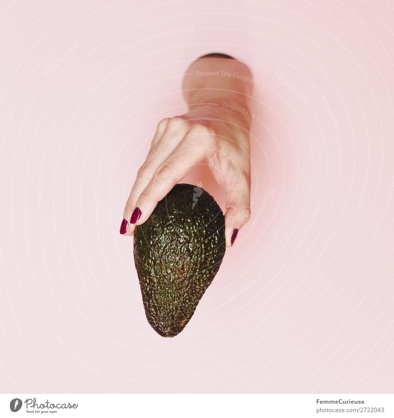 Hand of a woman holding an avocado 1 Mensch genießen Gesunde Ernährung Vegane Ernährung Vegetarische Ernährung Avocado festhalten rosa Vitamin Nagellack