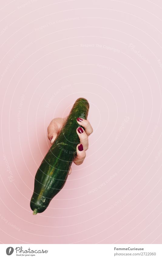 Hand of a woman holding a cucumber Lebensmittel Ernährung Frühstück Mittagessen Abendessen Picknick Bioprodukte Vegetarische Ernährung Diät genießen