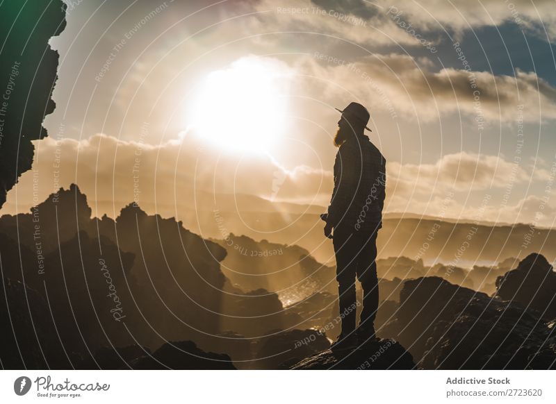 Tourist, der an sonnigen Tagen auf einer Klippe steht. Natur Mann bärtig Hügel Berge u. Gebirge Sonnenuntergang Abend Silhouette Ferien & Urlaub & Reisen
