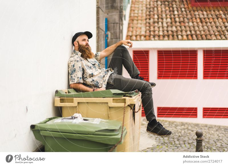 Bartiger Mann auf Müllcontainer sitzend Großstadt Straße bärtig Müllbehälter Container Lifestyle Jugendliche Stadt Mensch Typ Coolness Stil Erwachsene