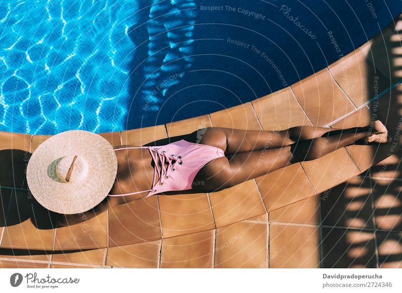 Schwarze Frau, die in einem Swimmingpool liegt. schwarz urwüchsig Schwimmbad Sommer Sonnenbad Ferien & Urlaub & Reisen Bräune horizontal Bräunen Erholung