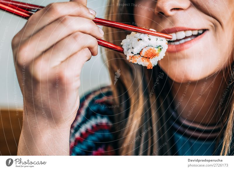 Getreidefrau beim Sushi essen Frau Lächeln Hand Lebensmittel Soja maki Kalifornische Walze Essstäbchen Brötchen Feldfrüchte unkenntlich anonym Nahaufnahme