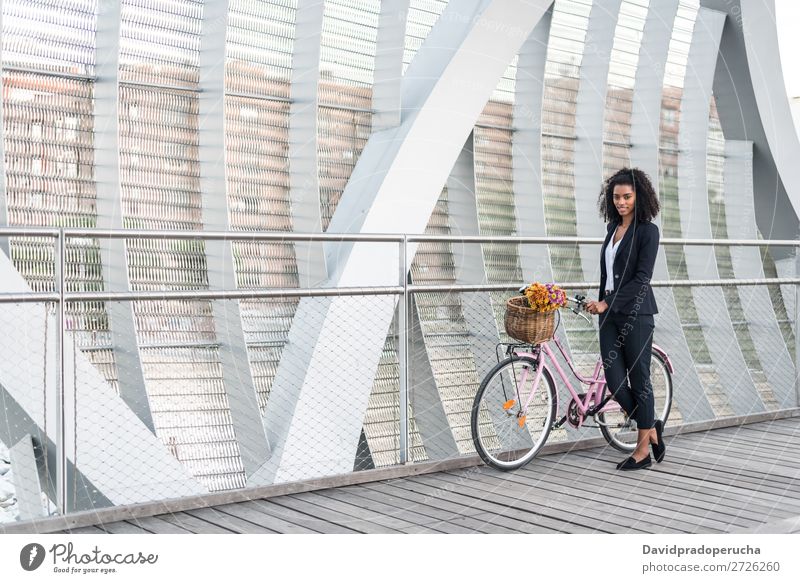Geschäftsschwarze Frau mit Vintage-Fahrrad in einer Brücke Business Fahrradfahren altehrwürdig Person gemischter Abstammung Großstadt Jugendliche Mensch Anzug