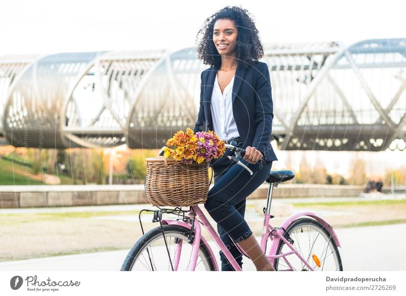 Geschäftsschwarze Frau auf einem Oldtimer-Fahrrad in der Stadt Business Fahrradfahren altehrwürdig Person gemischter Abstammung Großstadt Jugendliche Mensch