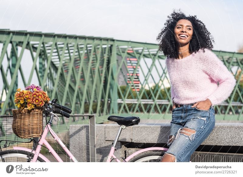 Schwarze junge Frau auf einem Oldtimer-Fahrrad Mädchen altehrwürdig Ausritt schön retro Blume Sonnenstrahlen Glück Blumenstrauß Sommer Jugendliche hübsch