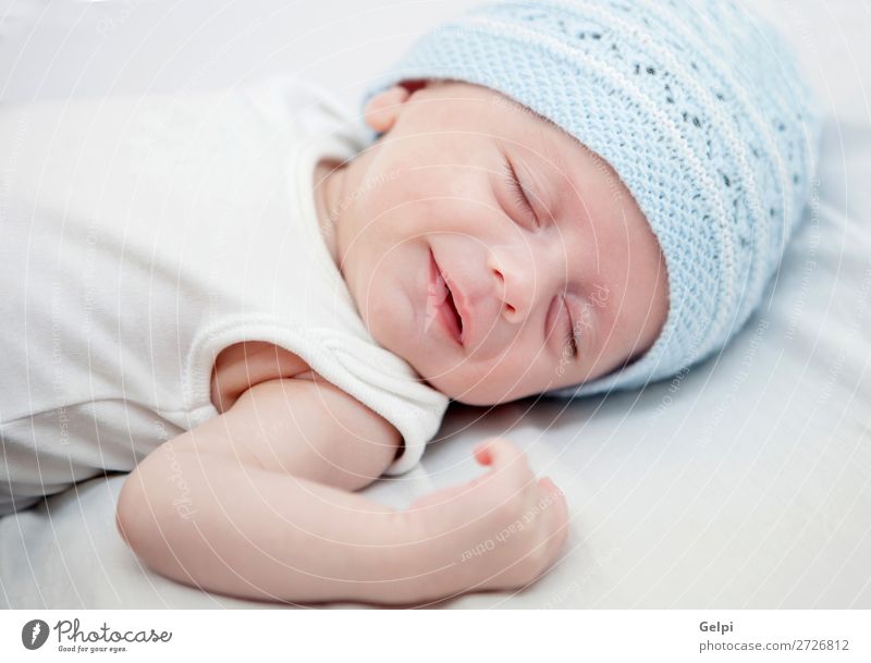 Baby mit blauer Kappe schläft friedlich. Lifestyle Freude Glück schön Haut Gesicht Leben Kind Mensch Kleinkind Junge Mann Erwachsene Kindheit Wärme Hut Lächeln