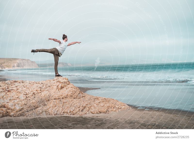 Der Mensch balanciert auf dem Felsen des Ozeans. Mann Meer Gleichgewicht ruhig Freiheit stehen Frieden Yoga Erholung Konzentration Strand Natur Außenaufnahme