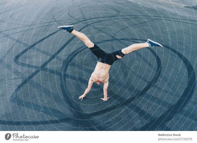 Anonymer Mann, der auf dem Bürgersteig tanzt. Tänzer Gleichgewicht Straßenbelag Handstand Breakdancer akrobatisch sportlich Sport Körperhaltung ohne Hemd Artist