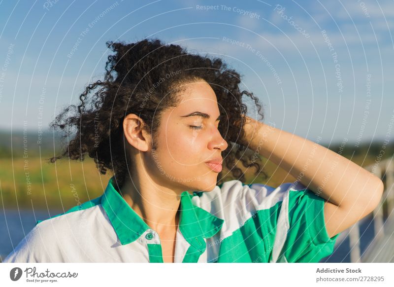 Sinnliches Modell, das im Sonnenlicht posiert. Frau Sommer Landschaft genießen Körperhaltung Natur Farbe lockig Augen geschlossen Außenaufnahme Länder ländlich