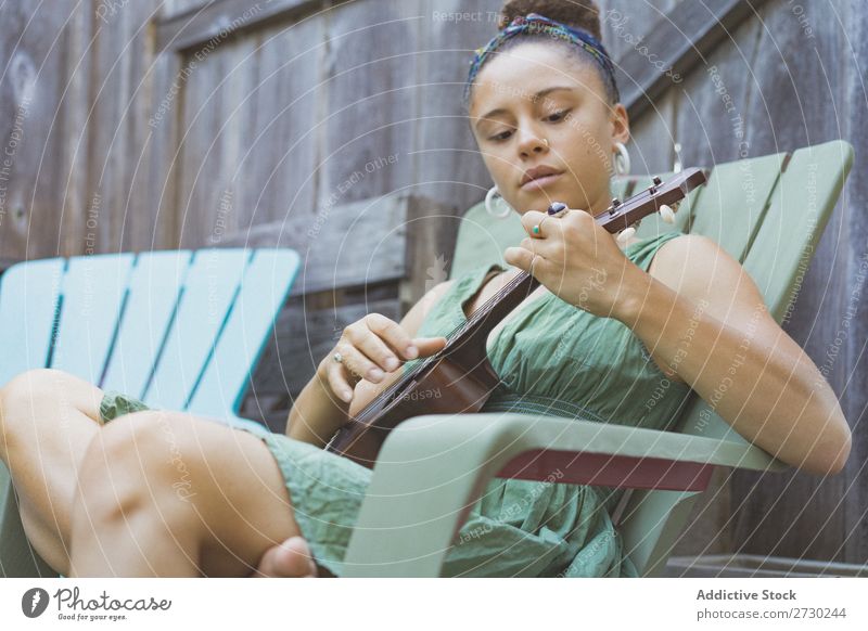Mädchen spielt Ukulele im Gartenstuhl Frau Musiker Erholung Sommer Gitarre Instrument schön Jugendliche Künstler Lifestyle Freizeit & Hobby Musical Klang