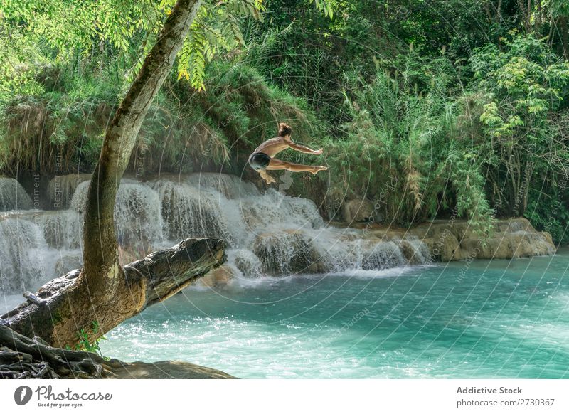 Mann, der in türkisfarbenes Wasser springt. Artist Natur extrem akrobatisch ohne Hemd springen Etage in der Luft See blau Gesundheit Lifestyle Sport
