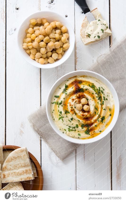 Hummus in der Schüssel und Pita-Brot auf weißem Holztisch. Lebensmittel Gesunde Ernährung Speise Foodfotografie Kichererbsen Koriander Zitrone Olivenöl
