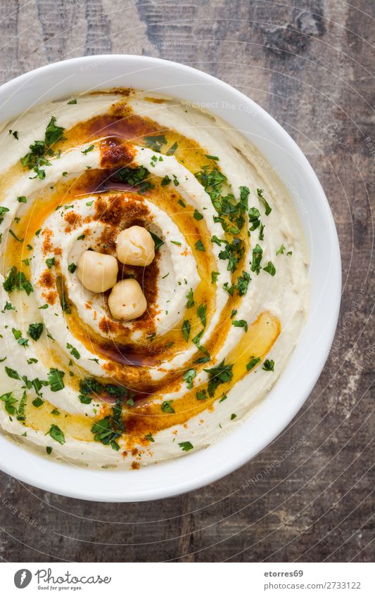 Hummus in der Schale auf Holztisch Lebensmittel Gesunde Ernährung Foodfotografie Kichererbsen Koriander Zitrone Olivenöl Vegane Ernährung arabisch Tahini