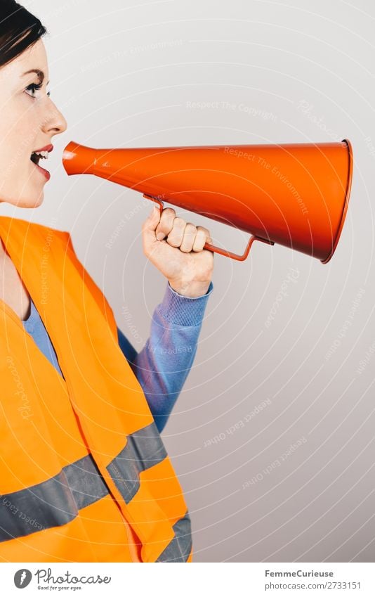 Woman in warning vest making announcement with megaphone feminin 1 Mensch Kommunizieren Respekt Ansage Durchsage Warnung Warnweste Weste orange rot Megaphon