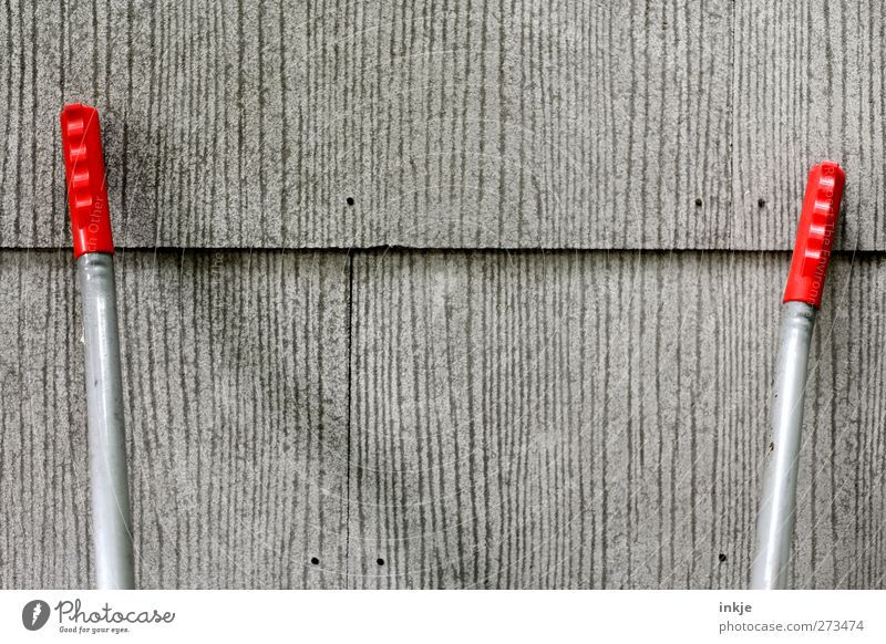 Zusammen ist man weniger allein Gartenarbeit Menschenleer Haus Mauer Wand Fassade Silikat-Mineral Plattenbau Schubkarre Griff trist grau rot 2 anlehnen Farbfoto
