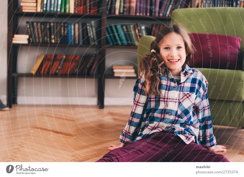 lustig glücklich 9 Jahre altes Kind Mädchen in der Bibliothek sitzend Freude Gesicht lesen Schule Eltern Erwachsene Kindheit Buch lachen schreien klein Wut