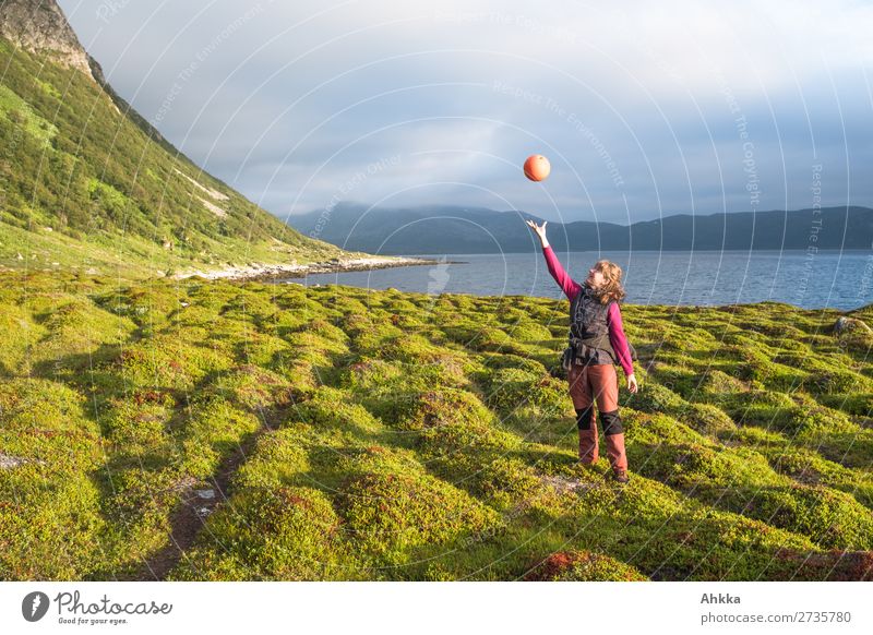 Junge Frau jongliert mit Treibgut Spielen Ferien & Urlaub & Reisen Jugendliche Natur Gras Küste Bucht Fjord Meer Norwegen fangen fliegen genießen Zufriedenheit