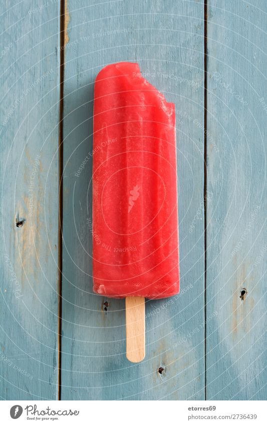Rotes Stieleis auf blauem Holztisch. Draufsicht Backwaren Kuchen rot Erdbeeren Sommer Eis Speiseeis kalt Lebensmittel Gesunde Ernährung Foodfotografie Dessert