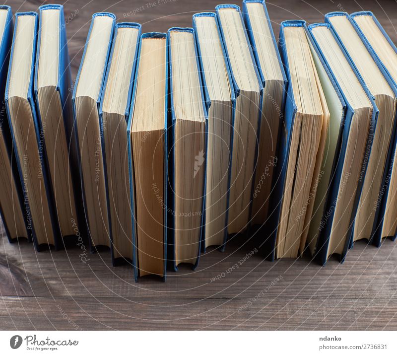 Stapel von Büchern in einem blauen Umschlag lesen Tisch Wissenschaften Schule Studium Menschengruppe Buch Bibliothek Papier Sammlung Holz lernen braun gelb