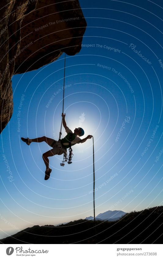 Kletterer auf ein Freiseil. Fitness Leben Abenteuer Berge u. Gebirge Klettern Bergsteigen Seil maskulin Mann Erwachsene 1 Mensch Felsen Gipfel hängen blau