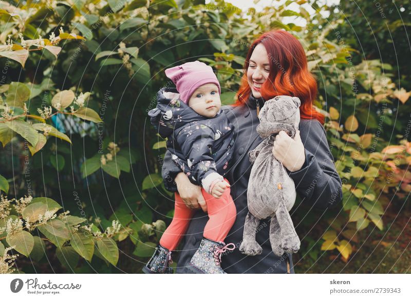 Glückliche Familie: Junge Mutter geht mit ihrem Kind im Park spazieren. Lifestyle Haare & Frisuren Gesundheit Freizeit & Hobby Spielen Ferien & Urlaub & Reisen