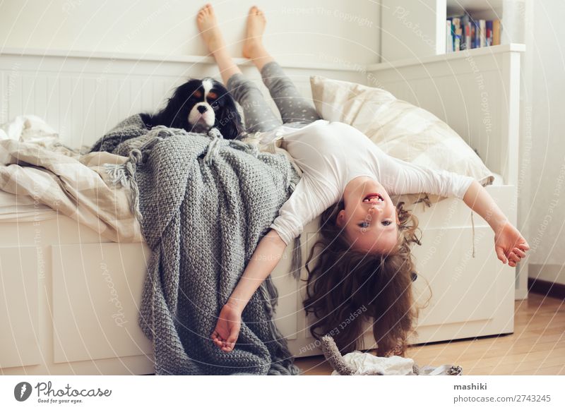 glückliches Kind Mädchen, das morgens aufwacht. Lifestyle Freude Glück Erholung Spielen Schlafzimmer Freundschaft Kindheit Haustier Hund Lächeln lachen schlafen