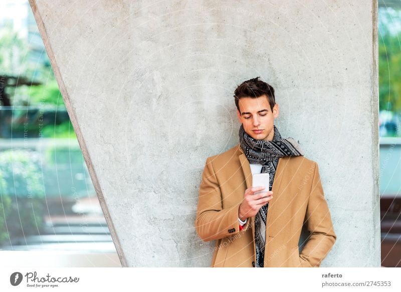 Junger Mann in Jeansstoffkleidung mit einem Handy Lifestyle elegant Stil schön Haare & Frisuren sprechen Telefon PDA Mensch maskulin Jugendliche Erwachsene 1