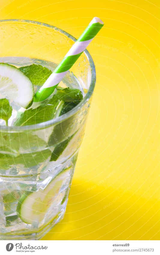 Mojito-Cocktail im Glas auf gelbem Hintergrund Getränk trinken Alkohol Erfrischung Sommer Kalk grün Minze Saft Rum kalt Eis Speiseeis Mischmaschine Frucht