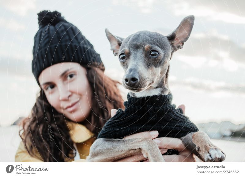 Frau mit ihrem kleinen Hund Lifestyle Erholung Ausflug Freiheit Winter Freundschaft Erwachsene Natur Tier Jacke Mantel Hut Haustier Liebe kuschlig gelb