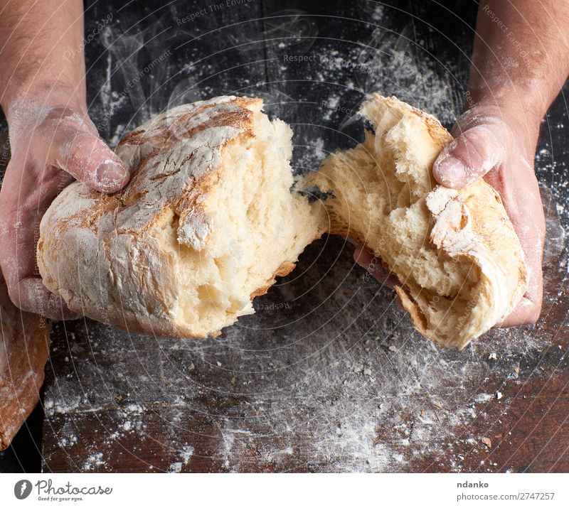 gebackenes Brot in zwei Hälften Ernährung Tisch Küche Beruf Koch Mensch Hand Finger Holz machen dunkel frisch heiß braun schwarz weiß Tradition Bäcker Bäckerei