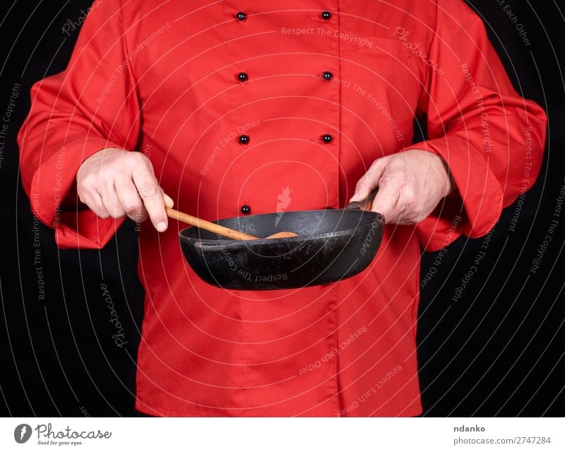 Koch mit einer leeren schwarzen Bratpfanne Pfanne Löffel Küche Restaurant Beruf Mensch Mann Erwachsene Hand Bekleidung rot Gußeisen Kaukasier Küchenchef