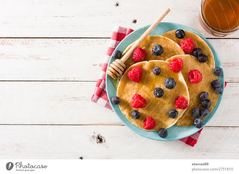 Pfannkuchen mit Himbeeren, Heidelbeeren und Honig süß Dessert Frühstück Blaubeeren Beeren blau rot backen Lebensmittel Gesunde Ernährung Foodfotografie Teller