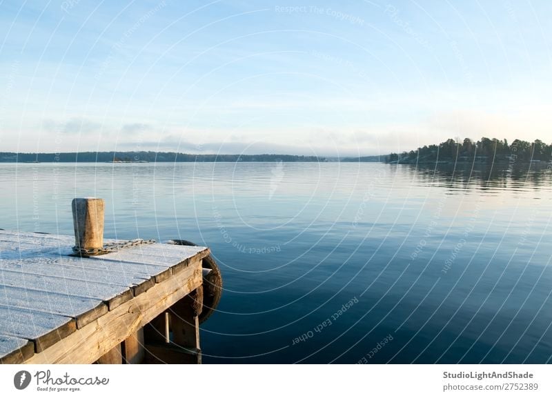 Blick über einen ruhigen See schön Erholung Insel Winter Natur Landschaft Himmel Küste Holz natürlich blau Gelassenheit Anlegestelle Kaje Wasser Seeufer