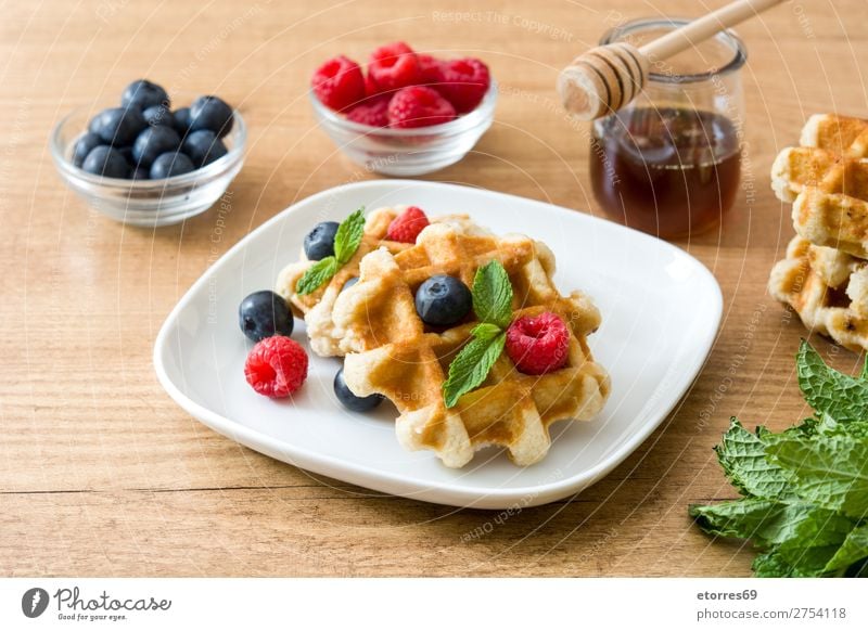 Traditionelle belgische Waffeln mit Heidelbeeren und Himbeeren Blaubeeren Minze Dessert süß Bonbon Frucht Gesundheit Gesunde Ernährung Frühstück Lebensmittel