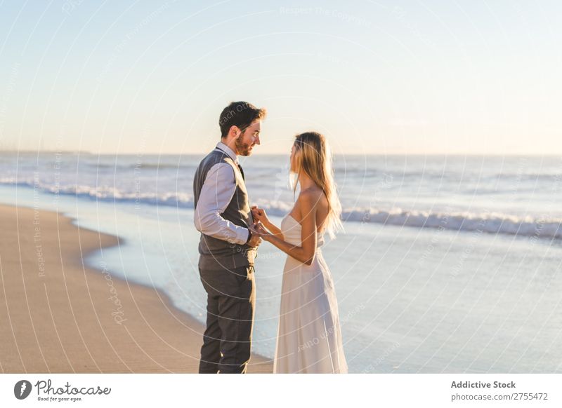 Zärtlich küssendes Brautpaar im Sonnenlicht Paar Hochzeit Strand Engagement Zufriedenheit Valentinsgruß Genuss verliebt Meereslandschaft stehen Partnerschaft