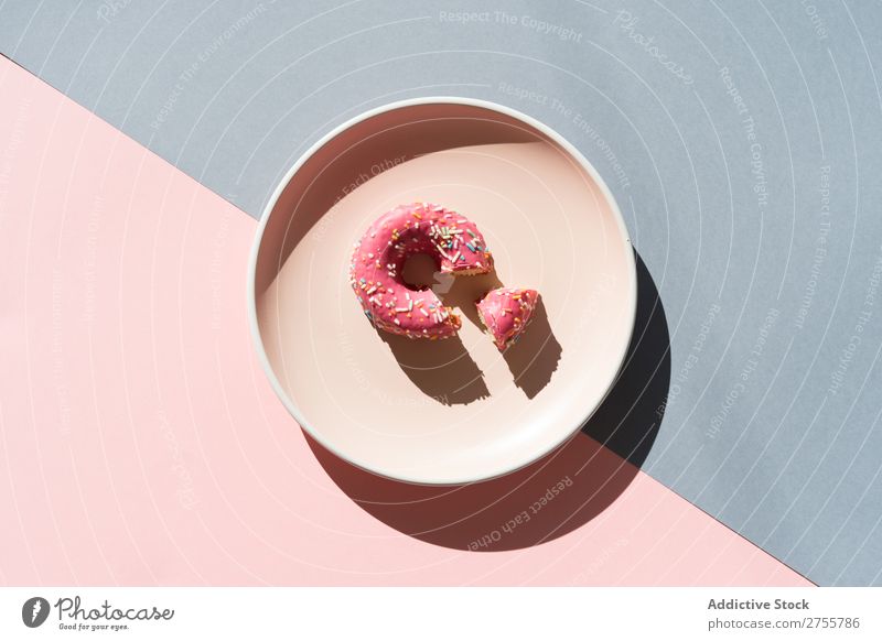 Köstlicher Doughnut auf Teller Zusammensetzung Krapfen mehrfarbig verglast minimalistisch geometrisch Symmetrie Konfekt Ordnung süß lecker Dessert Farbe rosa