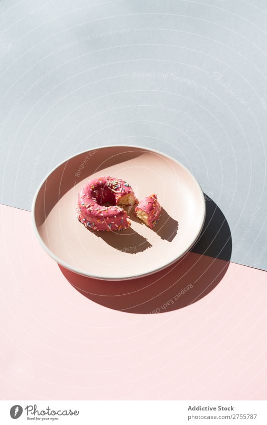 Köstlicher Doughnut auf Teller Zusammensetzung Krapfen mehrfarbig verglast minimalistisch geometrisch Symmetrie Konfekt Ordnung süß lecker Dessert Farbe rosa