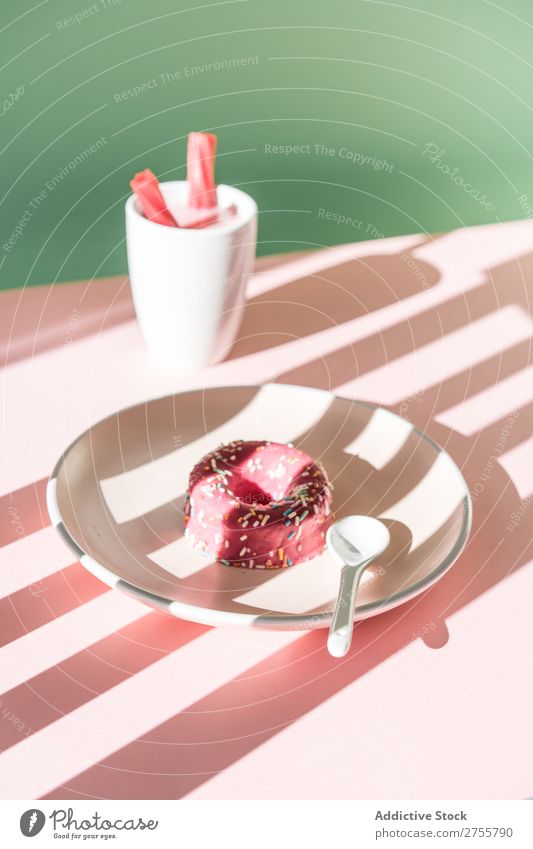 Bunte Donuts und Getränke im Sonnenlicht Zusammensetzung Krapfen trinken rosa lecker süß Dessert Streifen Backwaren Konfekt Kunst Teller Tisch Schatten Tasse